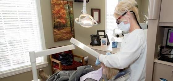 Dentist in white coat examining patient in dental chair at Lucke Dental office.