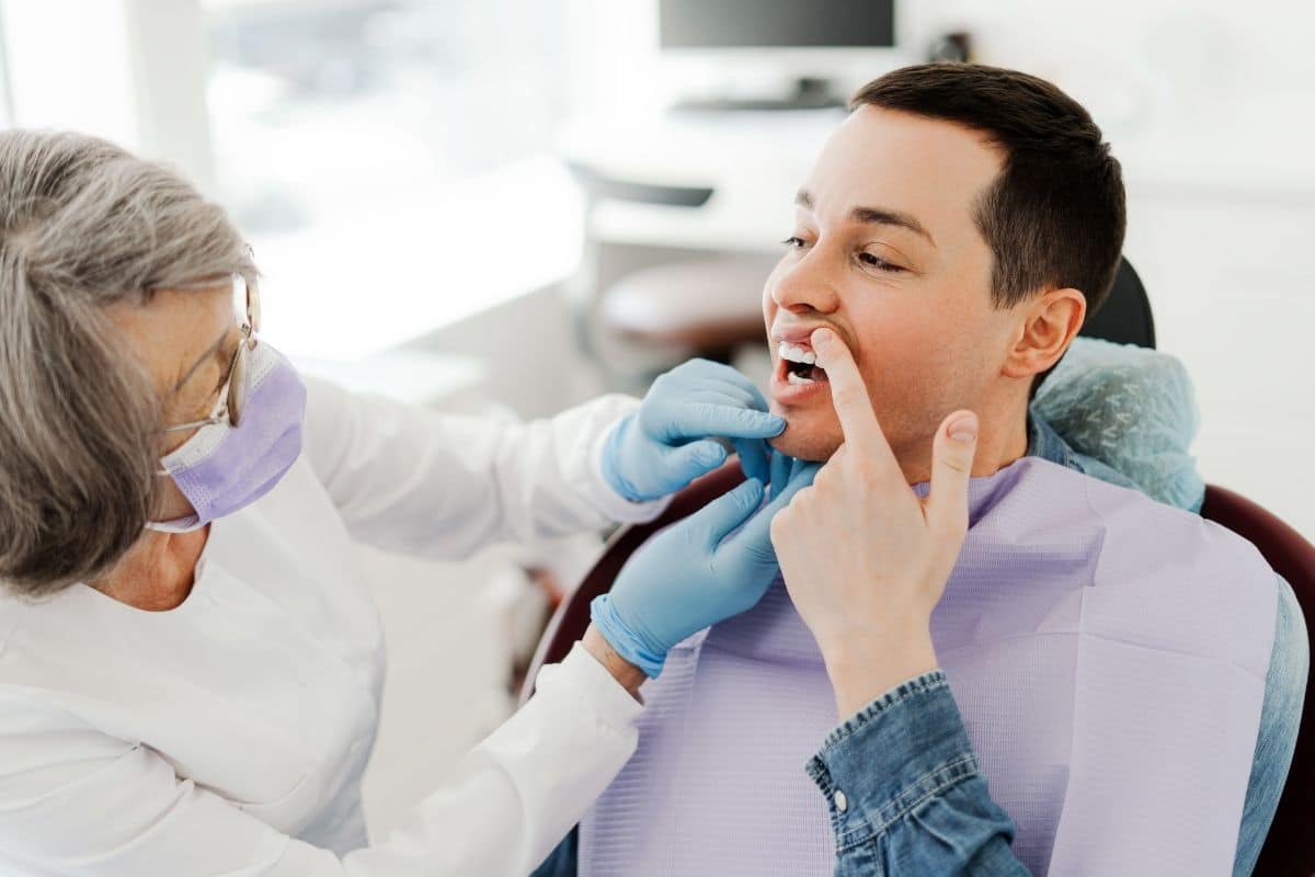 Dentist examining patient's mouth during oral health consultation in Fayetteville.
